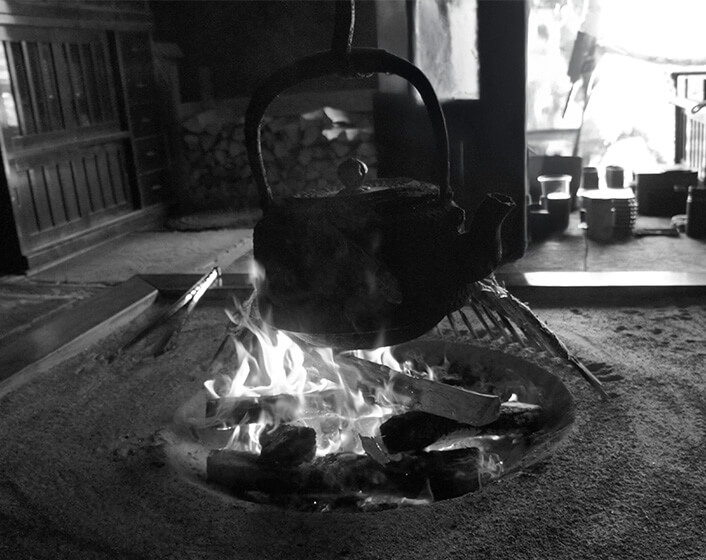 囲炉裏のある居間で自在鉤に吊るされ熱された鉄瓶