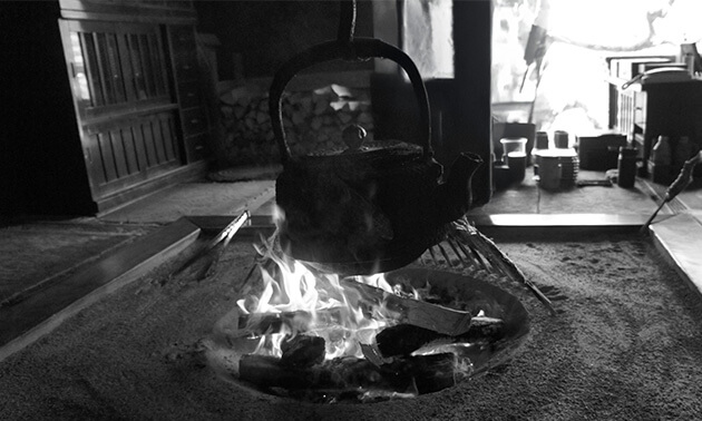 囲炉裏のある居間で自在鉤に吊るされ熱された鉄瓶